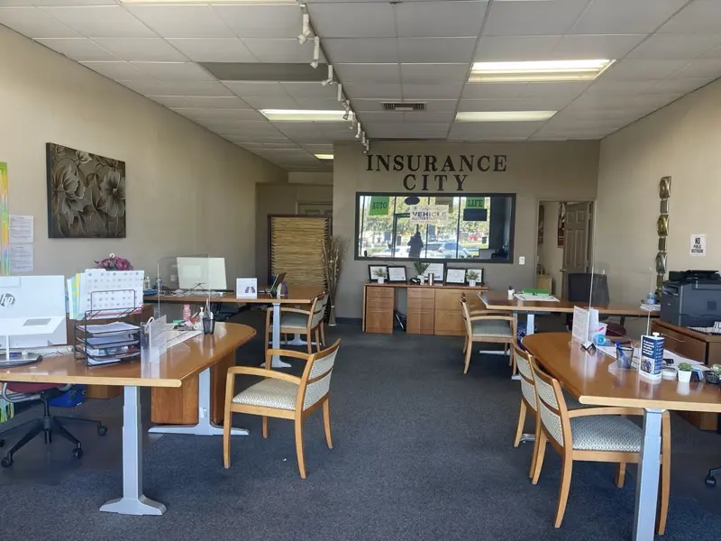 Inside the Insurance City office at 956 W. Robinhood Drive, Stockton — agent desks and the Insurance City sign on the back wall