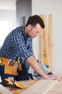 Male Contractor laying flooring down
